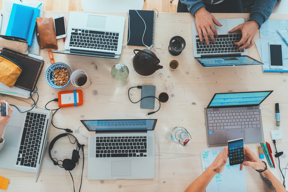Team reviewing a laptop together in a bright workspace